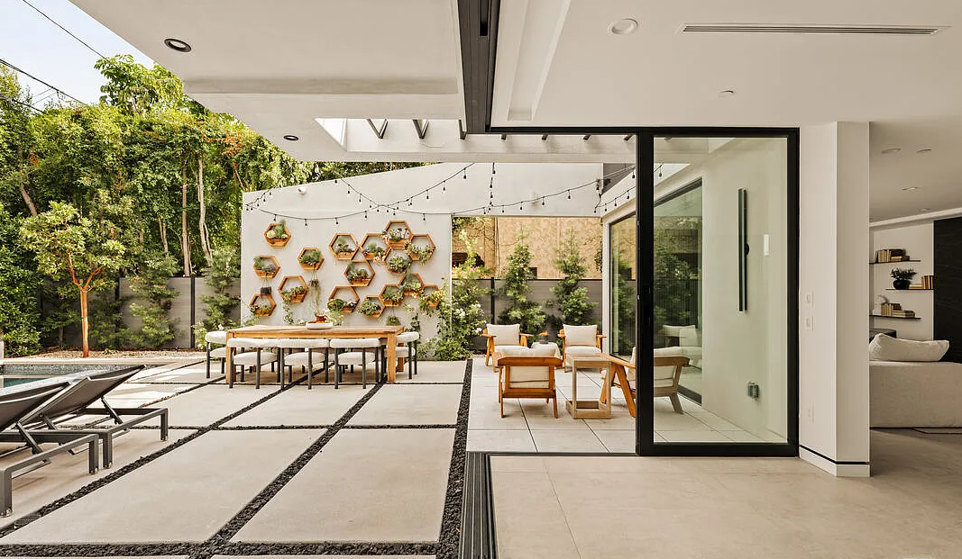 The great room opened to the covered terrace, with the hexagonal planter wall beyond, La Jolla North in West Hollywood by Apel Design