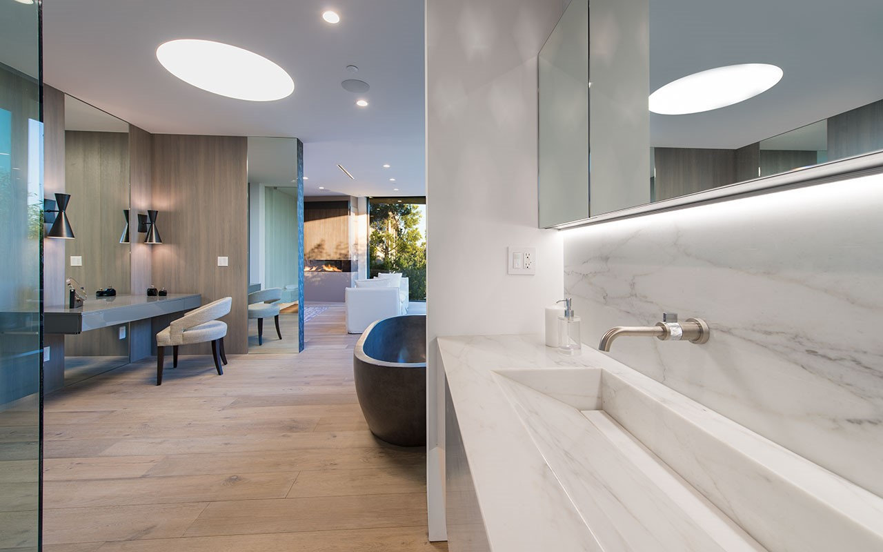 Bathroom at Shoreham with marble trough basin and oval ceiling light, by Apel Design