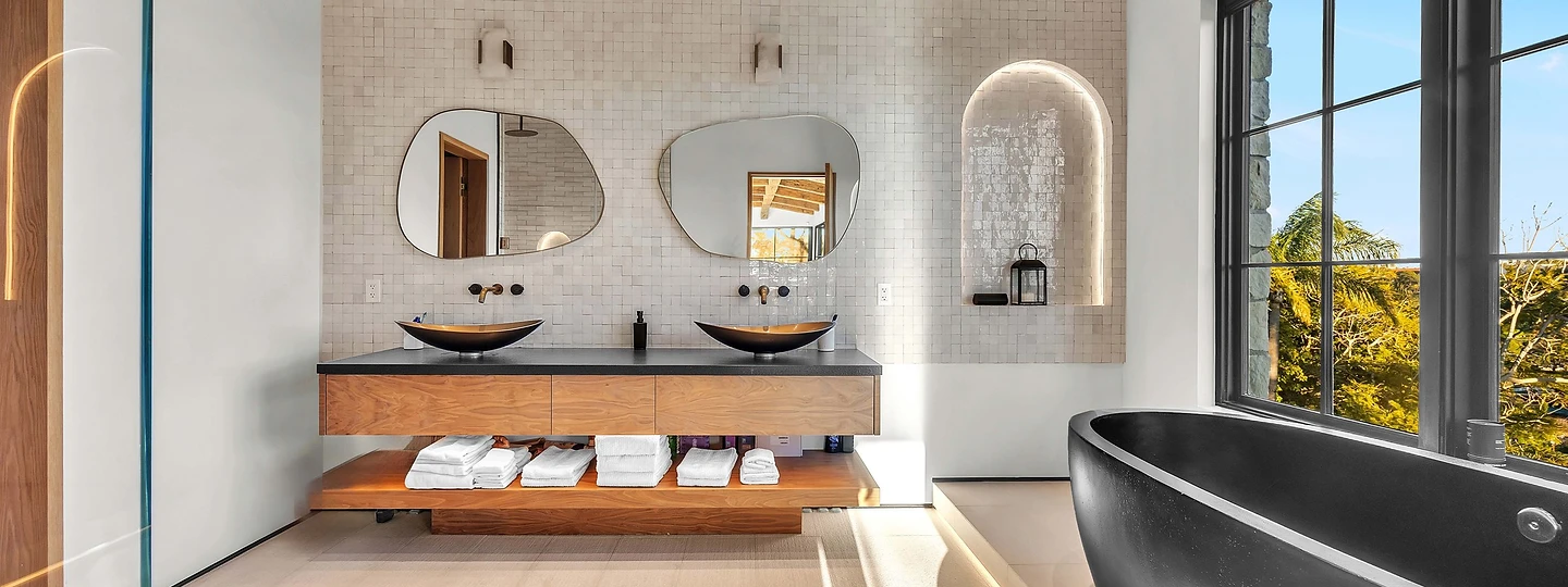 Primary bath with vessel basins on a floating timber vanity and a black freestanding tub, at Merritt Estate in Malibu, by Apel Design