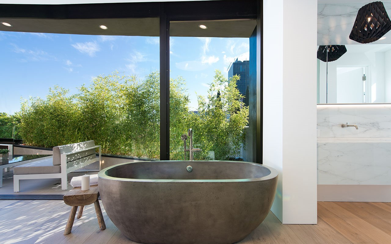 Freestanding concrete bathtub at Shoreham facing the bamboo terrace, by Apel Design