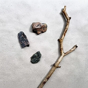 Natural stones and branch on textured paper