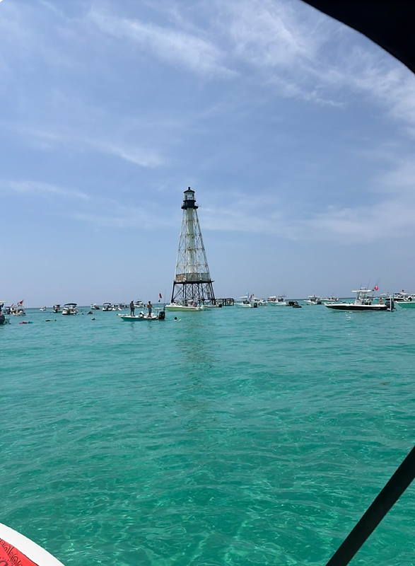 The rustic, metal-frame Alligator Reef Lighthouse standing in calm, turquoise water in the Florida Keys.