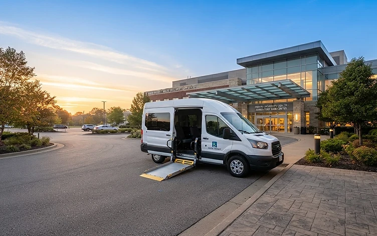 Triumph NEMT van parked in front of a modern Indiana medical facility at sunrise