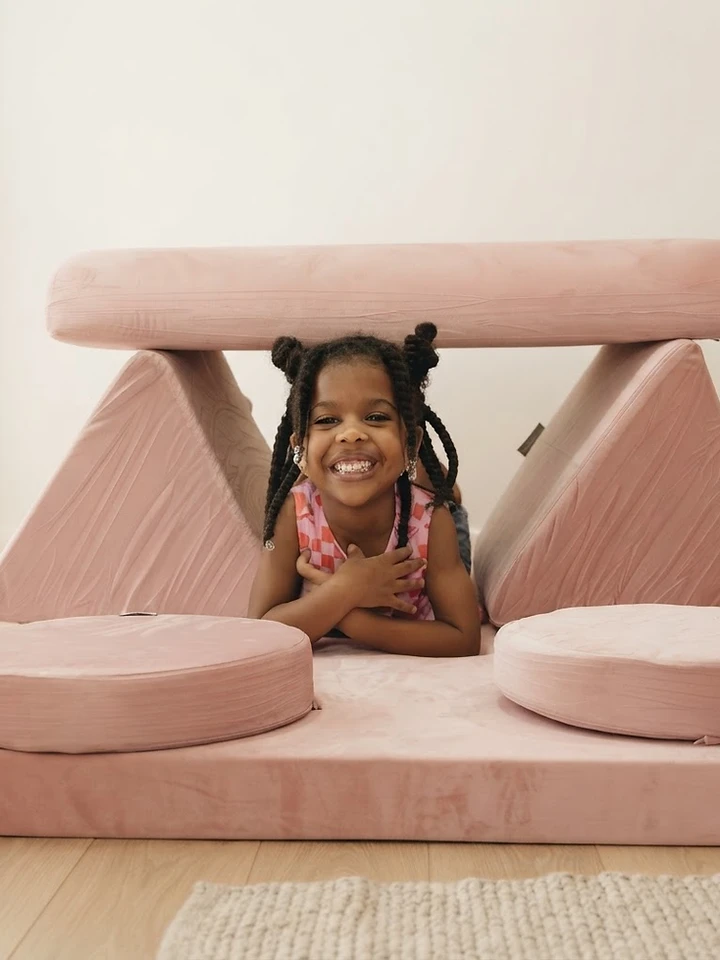 A child reading inside the Nanola play couch nook