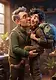 An elderly man in a sweater vest kisses his young grandson on the cheek in a cozy, cluttered workshop filled with scientific equipment.