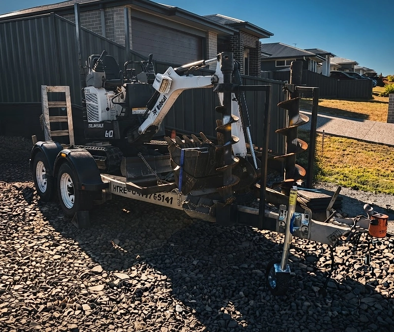 Mini bobcat loader on a Hervey Bay worksite at golden hour