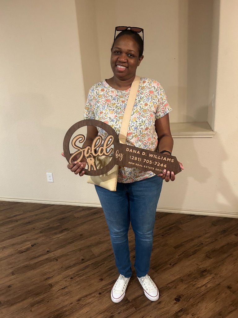 Woman holding a BDW Real Estate Group sold key