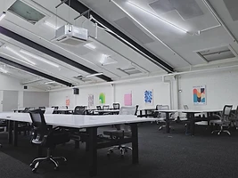 The desks — white workstations under skylights