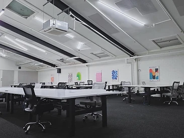The desks — white workstations under skylights