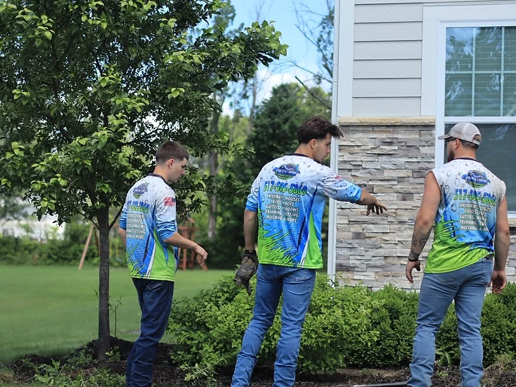 Greater Lansing Exterior Services crew in branded shirts at a residential jobsite