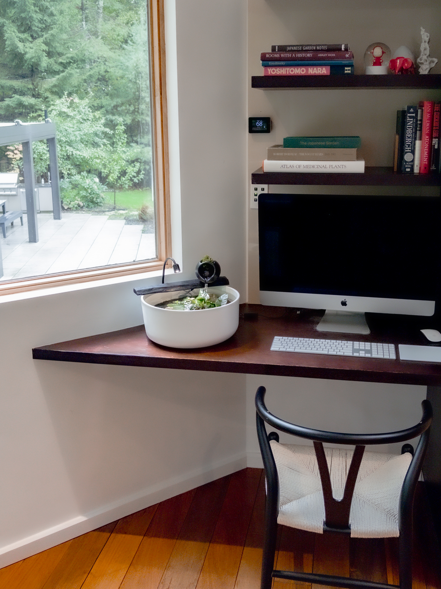 The Sanctuary Vessel on a triangular wooden desk beside an iMac and bookshelves