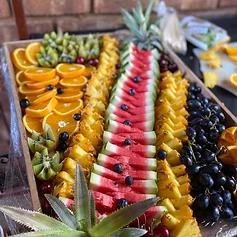 A rainbow fruit platter — oranges, pineapple, watermelon and grapes, fresh for the feast.