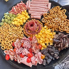 A snack platter built to share — salami rose, cheese, olives, pretzels and bites.