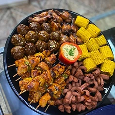 A loaded platter — meatballs, wings, skewers, corn and sausage for the crowd.