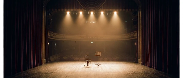 An empty theatre stage with warm spotlights
