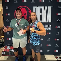 Two DBDB athletes with medals in front of the DEKA Strong backdrop
