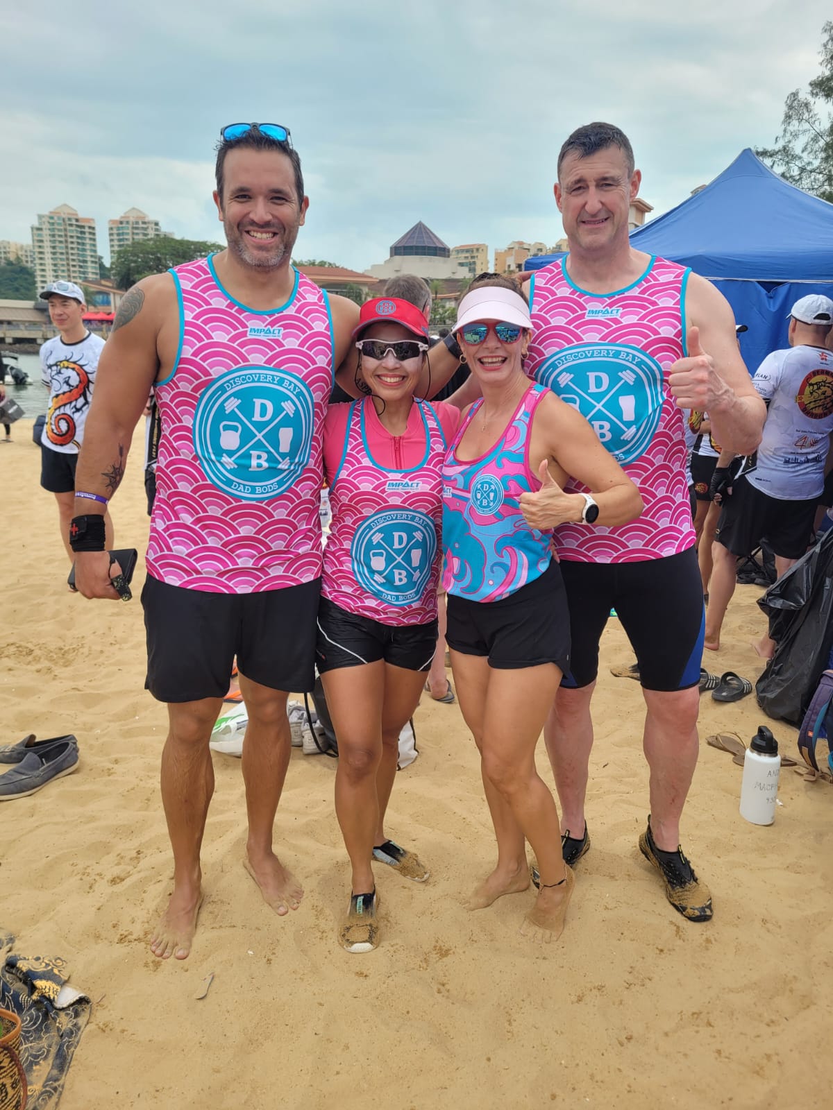Four of the crew in team kit after a race day at Discovery Bay beach