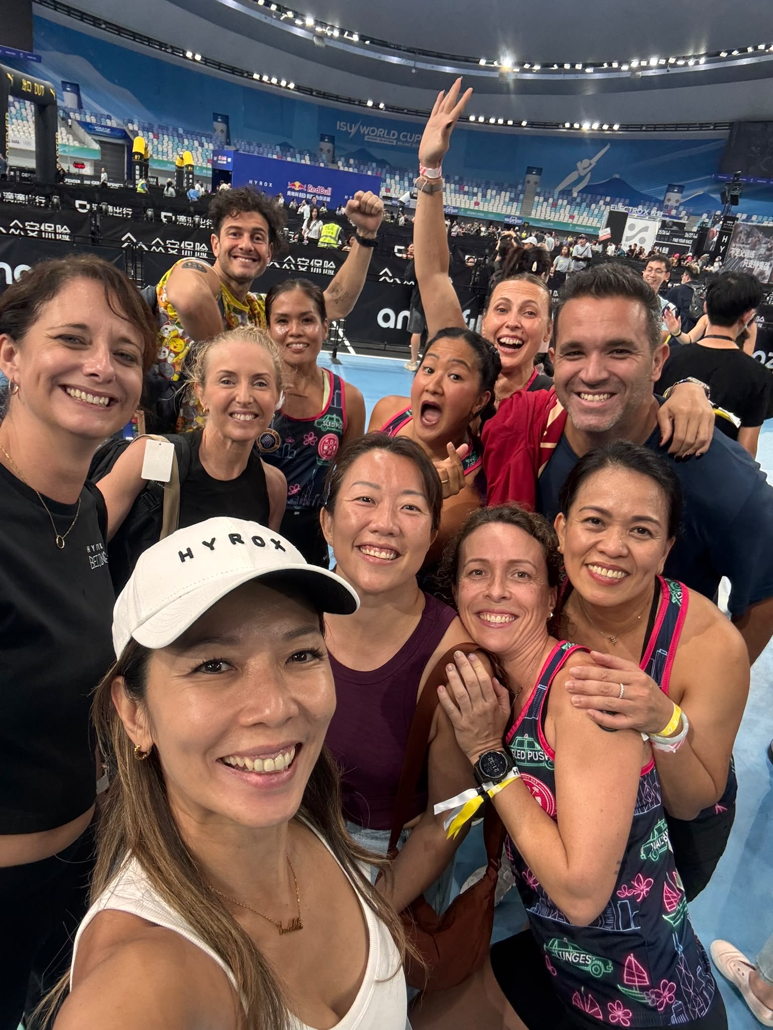 Twelve strong — the DBDB crew's post-race group selfie on the Beijing arena floor.