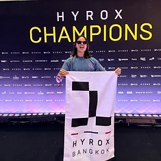 DBDB athlete holding the HYROX Bangkok Champions flag for Women 16-24