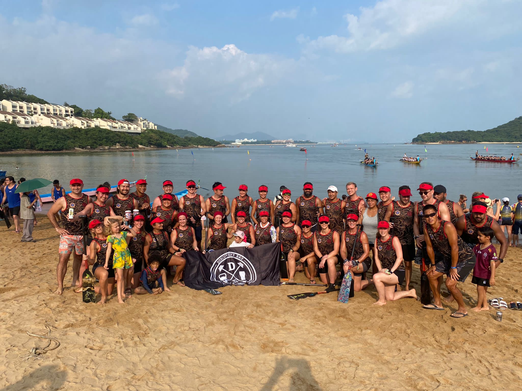 The full DBDB Dragon Boat crew with the Discovery Bay flag before a Community Race