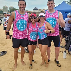 Four DBDB dragon boat teammates posing together on the beach