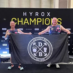 Two DBDB athletes holding the Discovery Bay Dad Bods banner