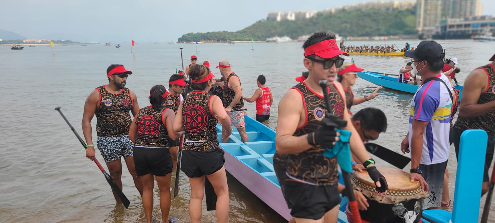 The crew boards the boat on race day — drummer at the ready, paddles in hand