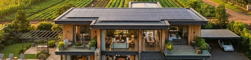 Modern solar-powered home surrounded by productive agriculture