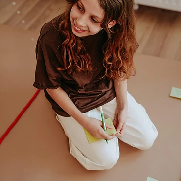 Mädchen mit Notizzettel im Workshop