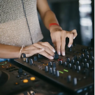 Close-up of hands adjusting sliders and knobs on a professional DJ mixer