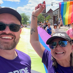 Two community members posing for a selfie during the Pride Halton 2026 parade on Main Street, Milton