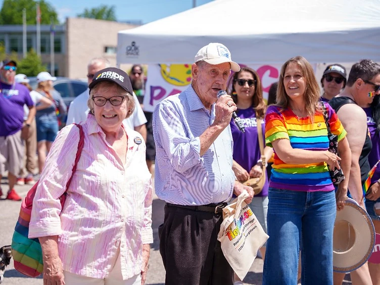 Mayor speaking at a Pride Halton community event alongside community members in Pride attire