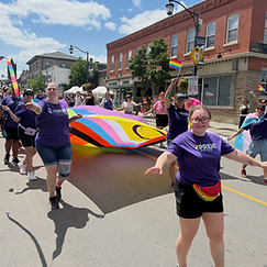 Pride Halton participant with arms outstretched celebrating at the 2026 parade in Milton