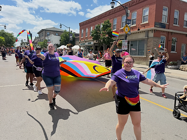 Pride Halton participant with arms outstretched celebrating at the parade