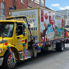 HeyRay.ca storage truck decorated with Pride flag pennants driving in the Pride Halton 2026 parade