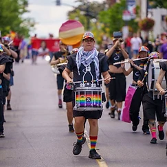 Marching band performing at the Pride Halton 2026 parade with rainbow-wrapped drums
