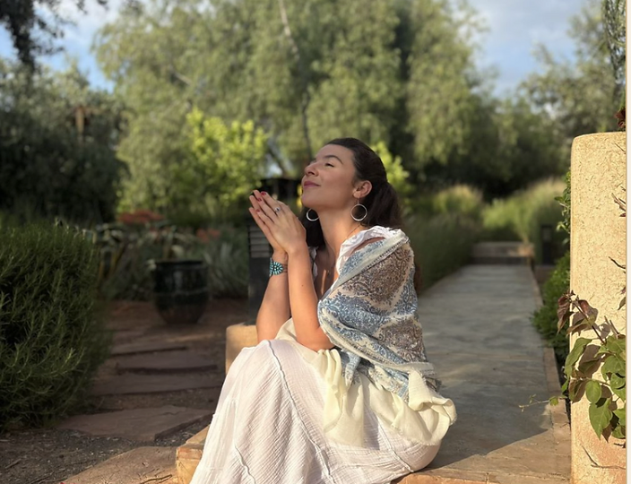 Mira Tarabeine holding a rose in the garden