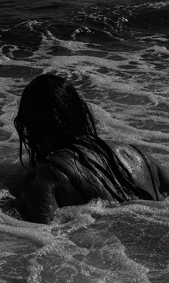 A person immersed in ocean water at dawn