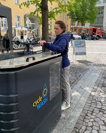 Besucherin bedient die mobile Fahrradwaschanlage auf einem öffentlichen Mobilitätsevent