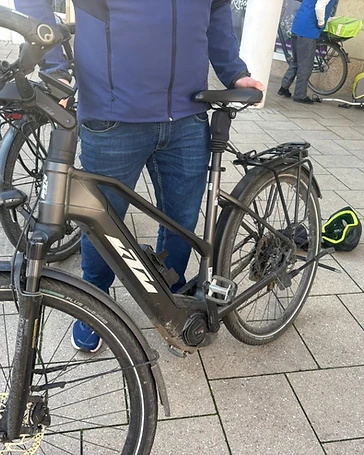 Bedienung der cycleWASH Station — Mitarbeiter führt ein E-Bike in die Waschbürsten
