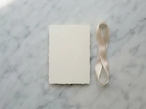 Elegant invitation card with a silk ribbon resting on a marble surface