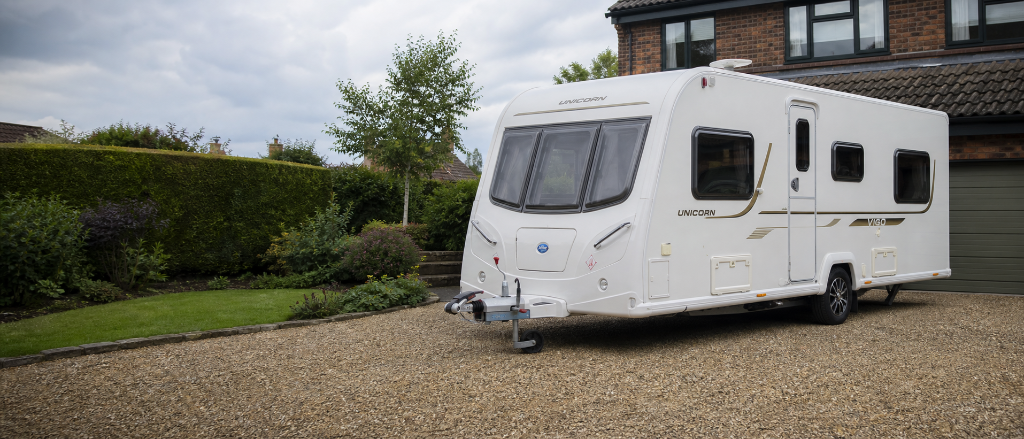 A touring caravan parked on a clean driveway in the UK