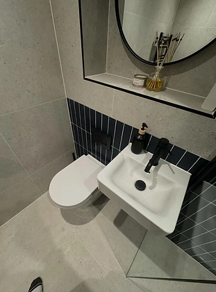 Wall-mounted bathroom vanity and basin against navy blue feature tiles