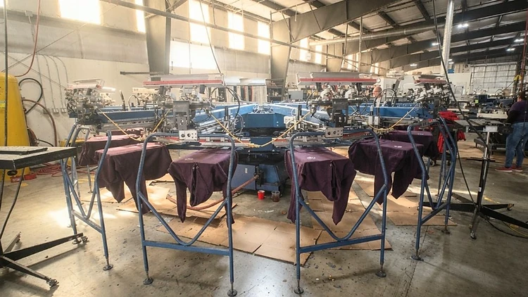 Industrial automatic screen printing press running on the production floor