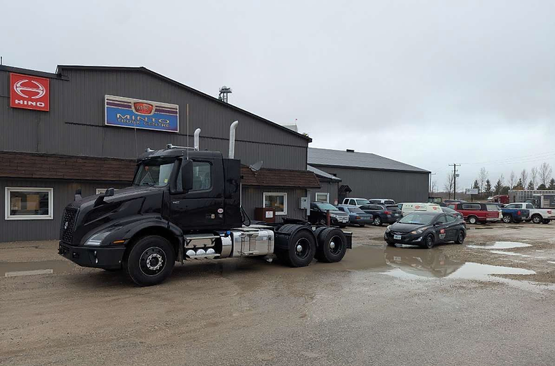 Black Volvo semi-truck parked at Minto Truck Centre with Hino and Minto signage