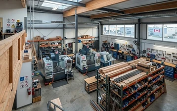 Vue en hauteur d’un atelier manufacturier vide avec équipements CNC et puits de lumière
