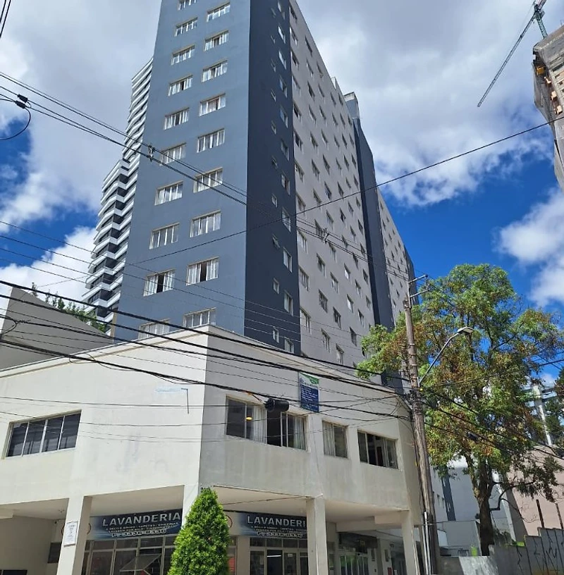Edifício residencial com fachada revitalizada em tons de azul e cinza sob céu azul