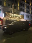 NEO Elite's black Ford Expedition outside the Great Lakes Theater marquee at Playhouse Square in Cleveland at night
