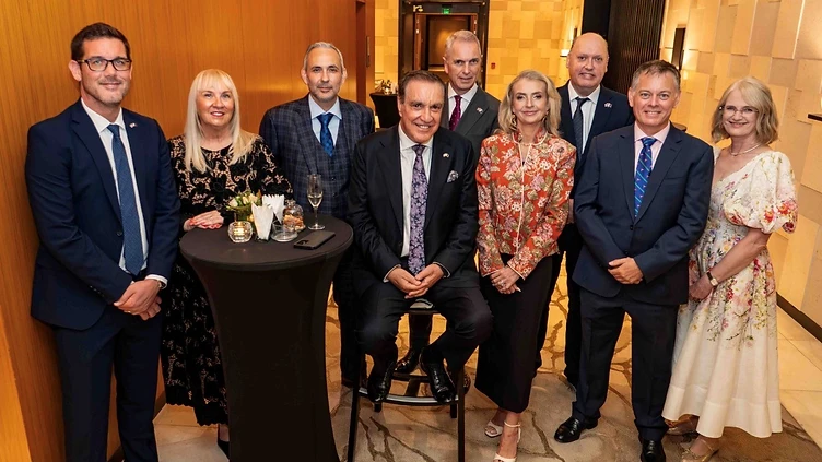 Nine attendees posing together at the British Chamber of Commerce Qatar Celebration Evening at Park Hyatt Doha.