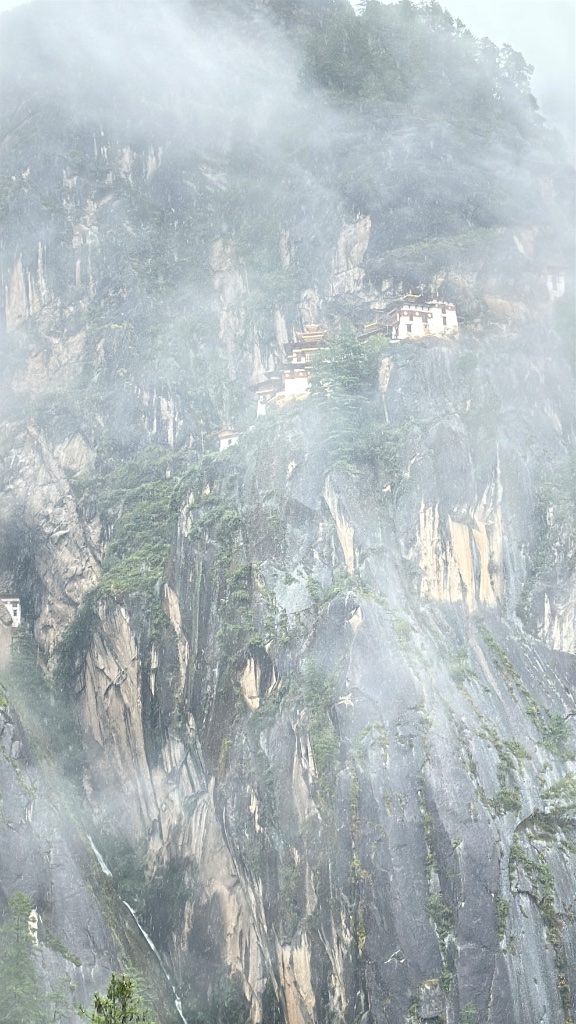A cliffside monastery shrouded in mountain mist